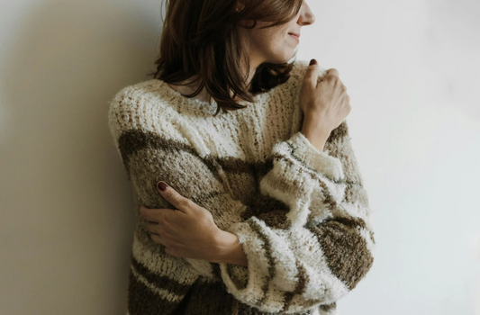 短髮女子抱着自己，呈現安靜自我安撫的情緒畫面